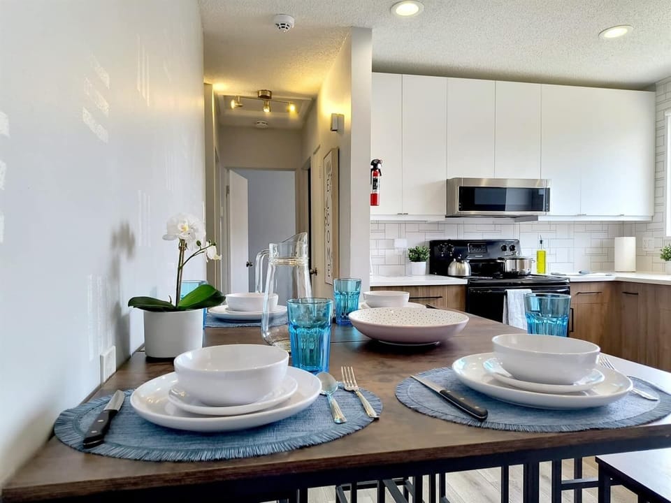 Gather around this inviting dining space, where stylish table settings and a modern open-concept kitchen create the perfect spot for shared meals and conversation.
