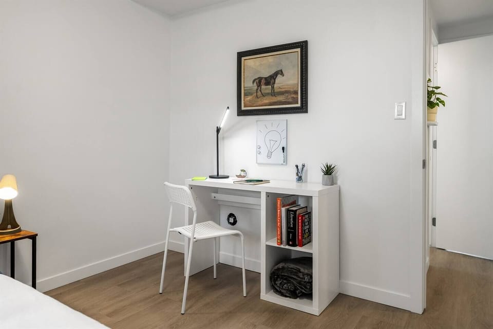 A cozy and functional workspace featuring a minimalist desk setup, perfect for reading, studying, or getting work done in peace.