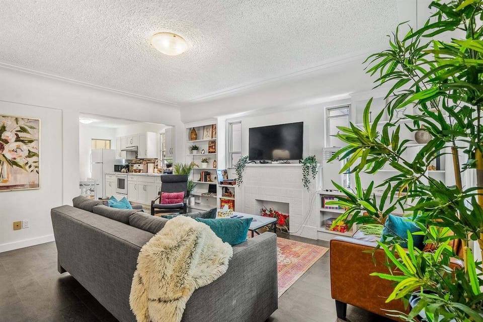 Cozy up in this vibrant and welcoming living room complete with smart TV, colorful accents, and plenty of space to relax or connect with loved ones.