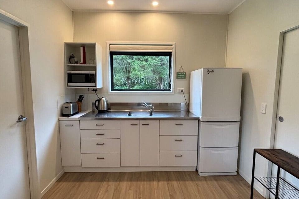 Kitchenette with fridge/freezer, microwave, toaster, jug, induction element.