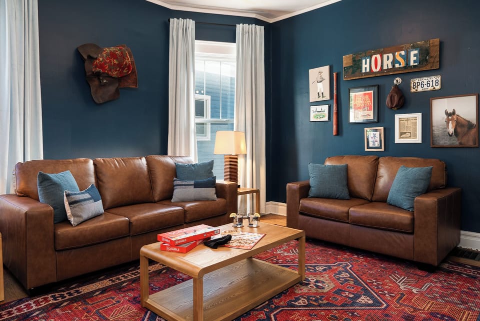 Living Room: Leather sofas, derby art, and a bold blue backdrop!