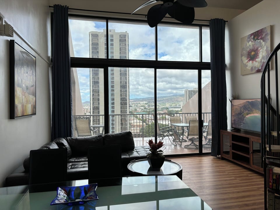 Living room with high ceiling sliding door to a large patio