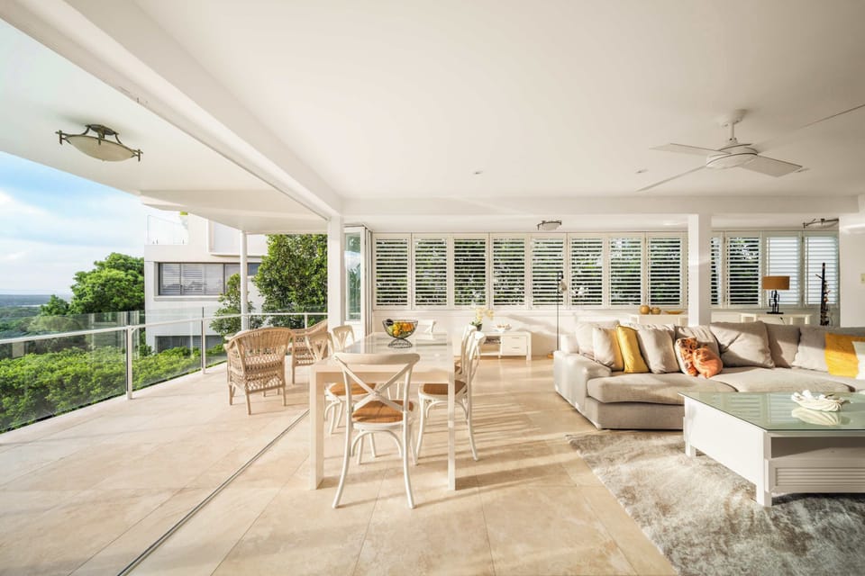 The open-plan living and dining area is light-filled and air-conditioned, designed to invite the outdoors in via wide bi-fold doors that open onto a generous balcony