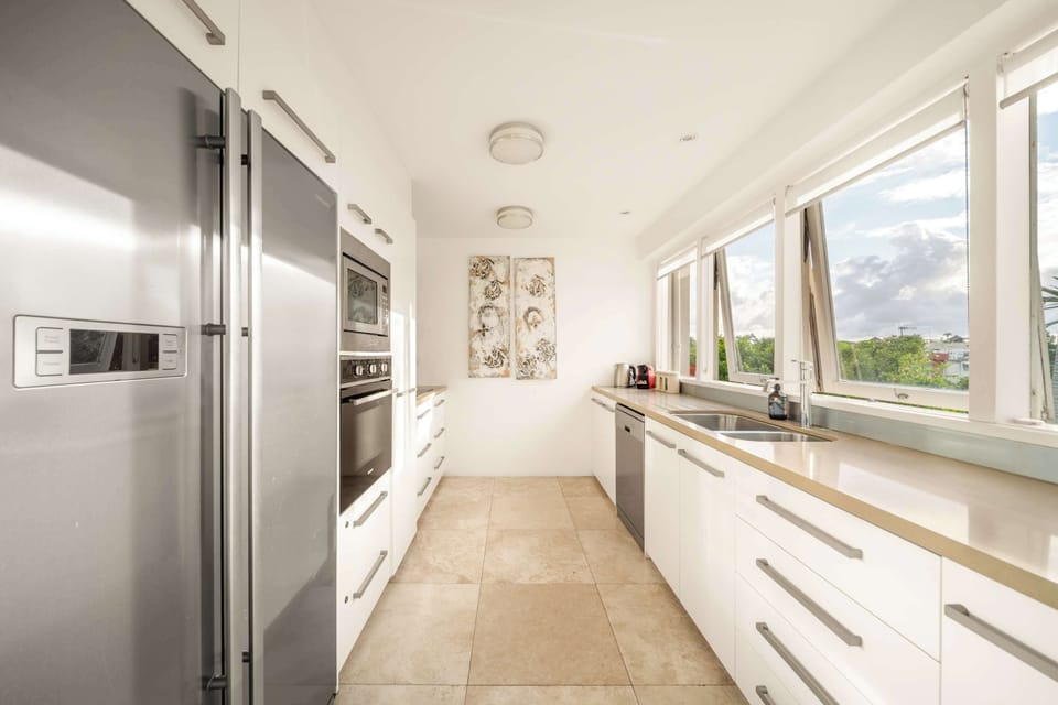 The fully equipped kitchen includes modern appliances and a Nespresso pod machine. Cooking with a view