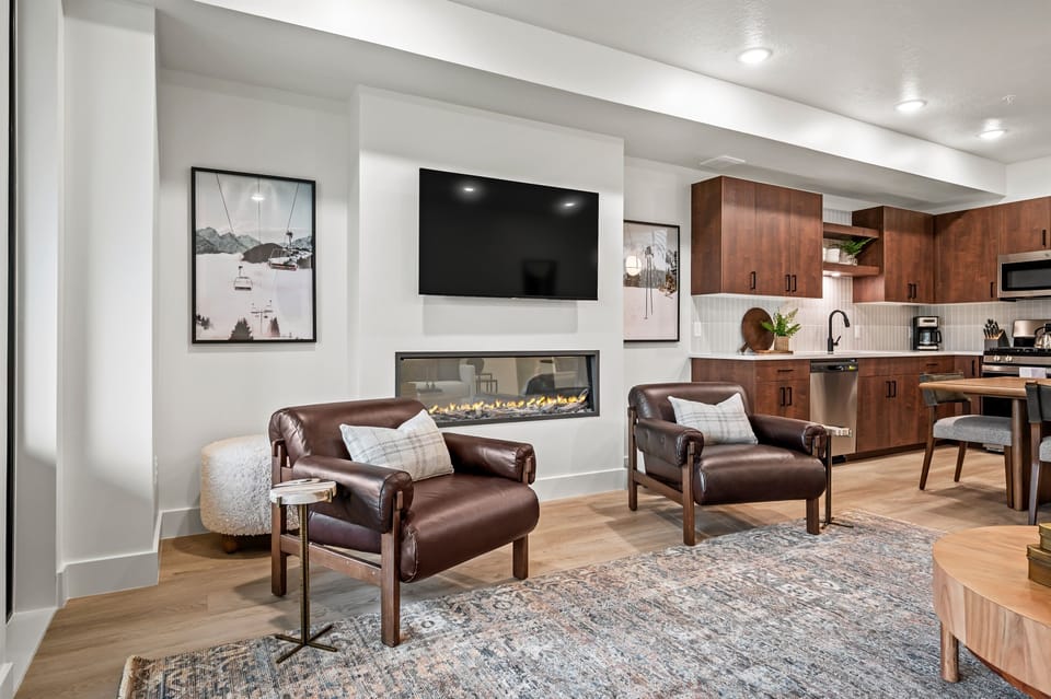 Relax in plush leather chairs by the fireplace, complete with a wall-mounted TV for movie nights.