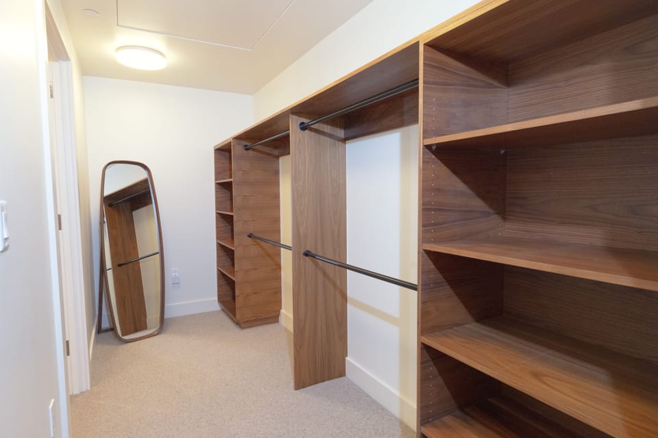 Your spacious walk-in closet awaits with custom wood shelving and hanging space for all your belongings, plus a full-length mirror to perfect your look each morning.