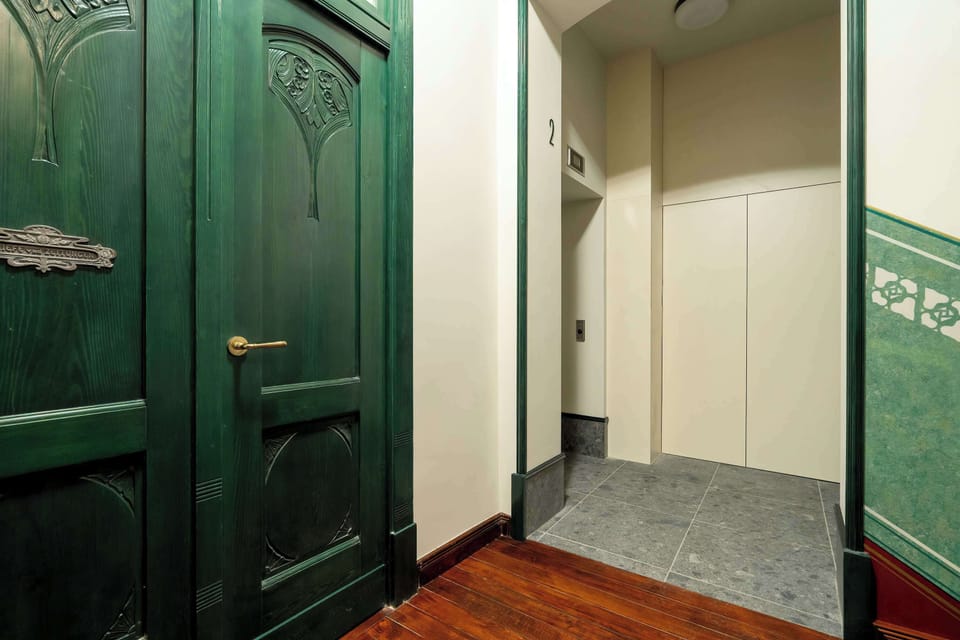 The historic entrance door with ornate details emphasizes the unique character of the townhouse.