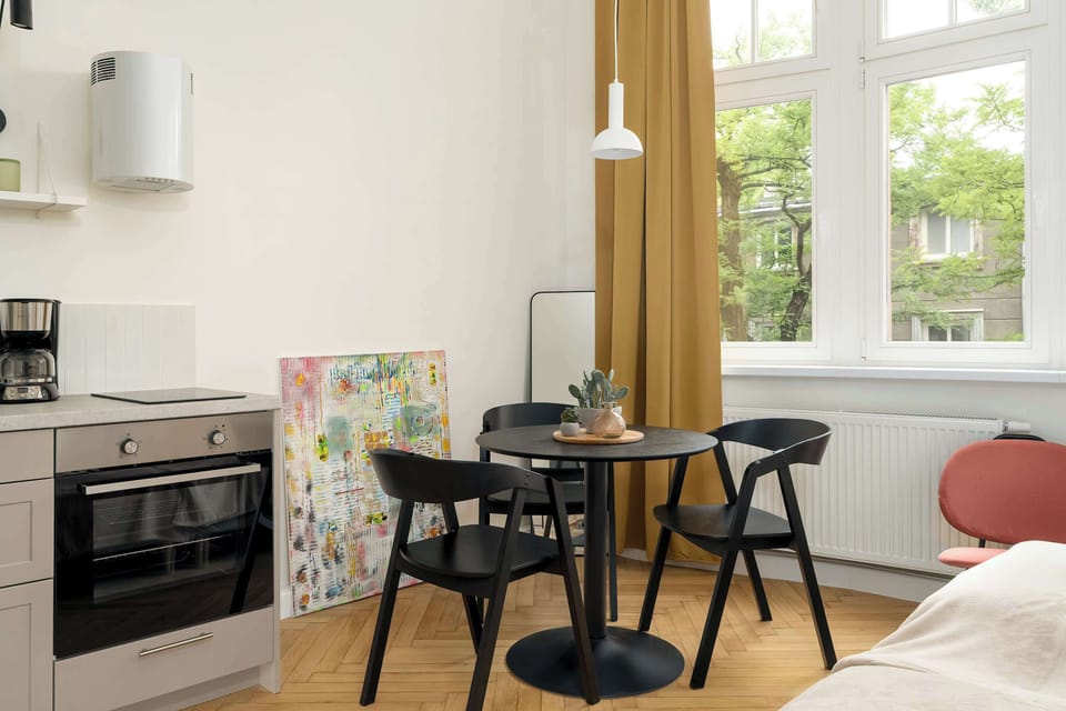 The bright kitchen with a large window and table creates a welcoming spot for shared meals.