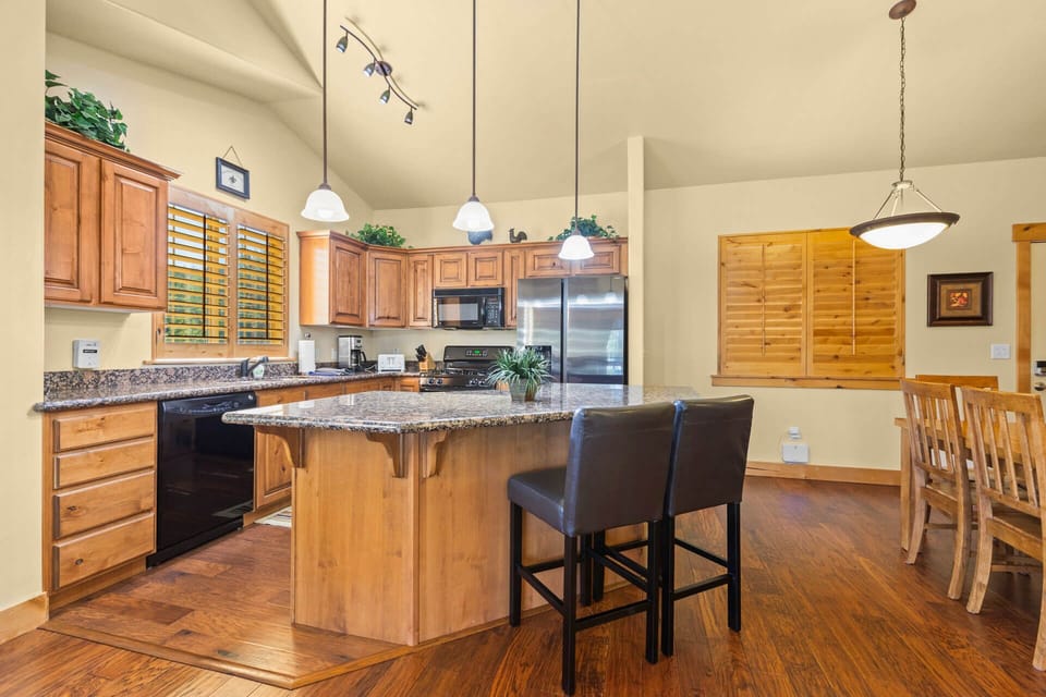 Your spacious kitchen invites you to gather around the granite island, where warm wood cabinetry and modern appliances make preparing meals a pleasure during your stay.