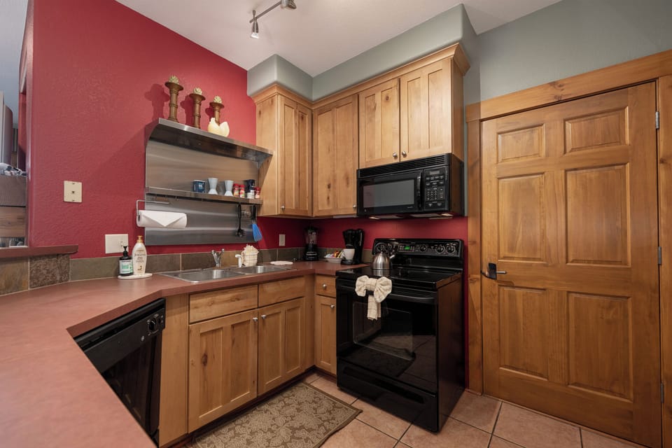 Your fully-equipped kitchen at Kicking Horse Maverick 5-203 features warm wood cabinetry and modern appliances, perfect for preparing meals during your stay.