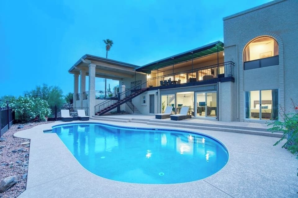 Your private desert oasis. Heated pool glows at dusk with stunning mountain backdrop.