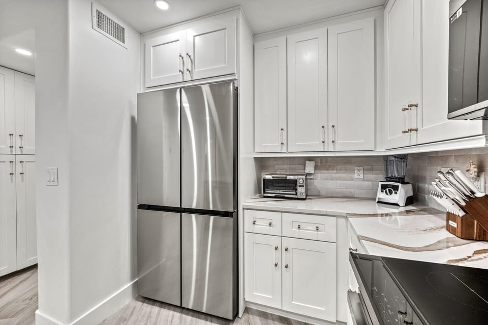 Stock it with local finds or sunset essentials—your full-size stainless fridge is ready for beach days and breezy nights in.