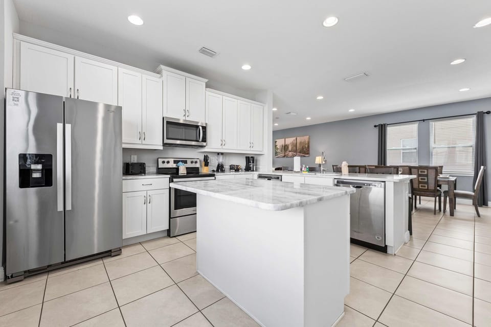 Modern kitchen with stainless steel appliances and spacious island for meal prep.