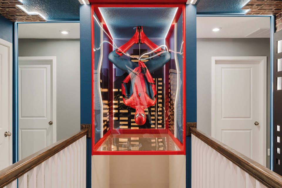 Discover a vibrant corridor with bold blue walls and an artistic figure in a striking red enclosure. The playful lighting invites you to explore this unique space and ignite your creativity.