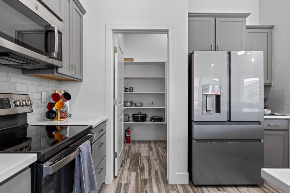 Fully stocked kitchen with Keurig coffee, olive oil, spices, and condiments.