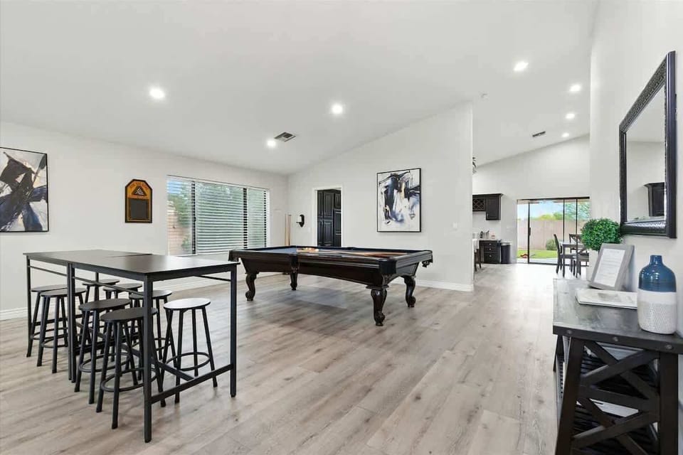 This game and entertainment area features a pool table and a bar table with seating for eight, making it a fun spot for games and group hangouts.