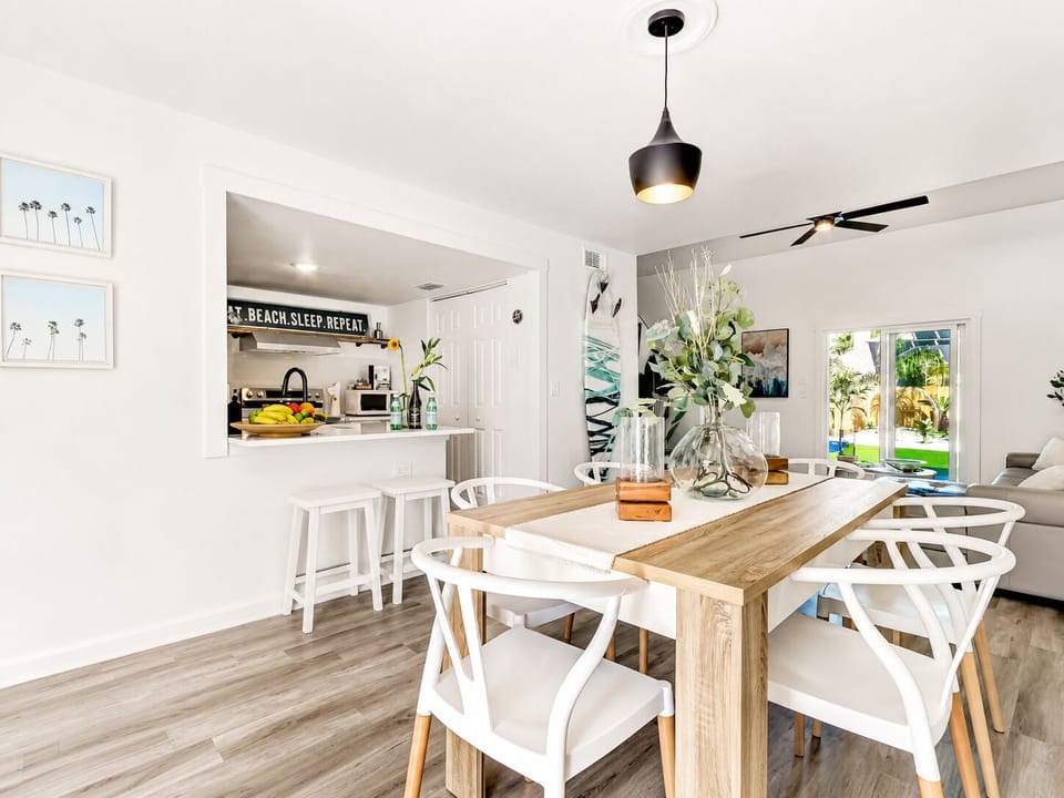 Bright coastal dining area with breakfast bar and garden views