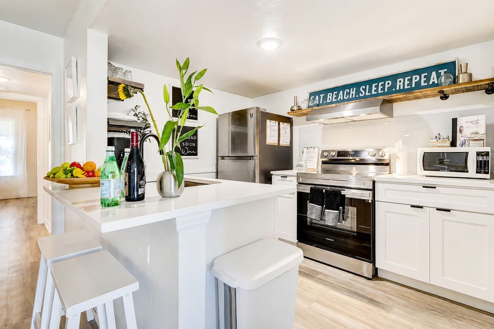 Bright coastal kitchen with breakfast bar and stainless steel appliances