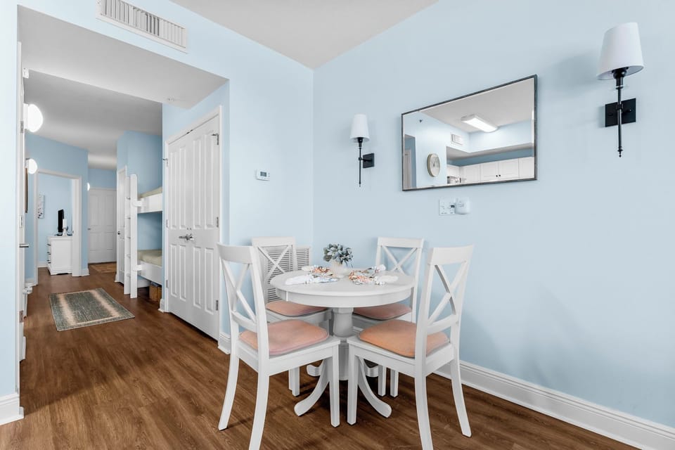 Cozy dining area with a round table and soft blue walls for a relaxing meal.