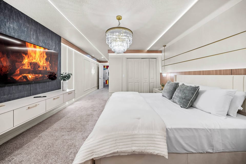 Enjoy relaxation in this beautifully designed bedroom with a plush king-size bed and soft linens. The ambient glow from the elegant chandelier and the sleek wall-mounted TV create a cozy and stylish atmosphere for your stay.