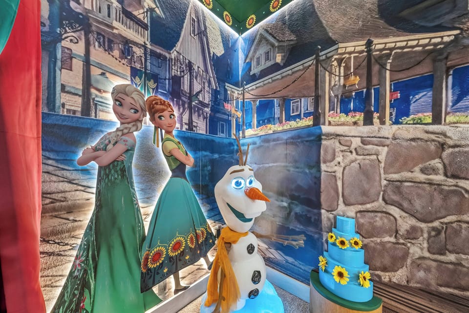 Discover a whimsical space filled with beloved characters that delight both kids and adults. The vibrant icy peaks and charming cottages create a playful atmosphere, while the cheerful cake adds a delightful touch to your visit.
