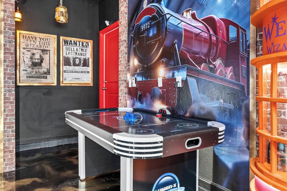 Enjoy a lively atmosphere with a sleek air hockey table beside a colorful steam engine mural. The industrial decor, with exposed brick and warm lighting, sets a relaxed yet energetic vibe ideal for friendly competition.