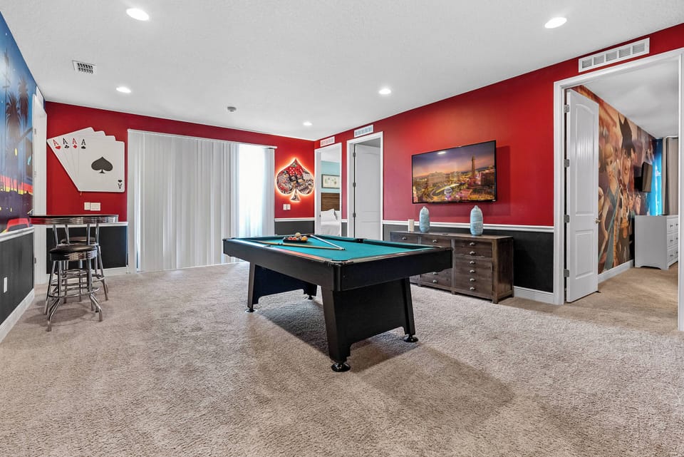 Enter our lively game room with bold red walls that set an energetic vibe for fun and relaxation. Enjoy friendly competition on the stylish pool table, all while natural light streams in through large windows.