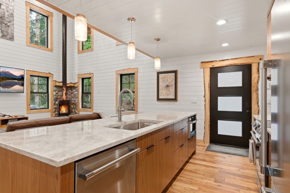 Cook, connect, and unwind. The open-concept layout blends a chef’s kitchen with a cozy great room anchored by a stone hearth and gas fireplace.