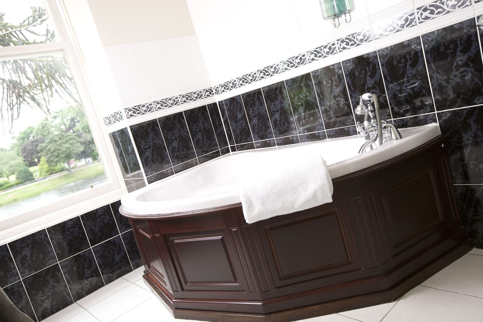 Deluxe King Room | Bathroom | Combined shower/tub, designer toiletries, hair dryer, bathrobes