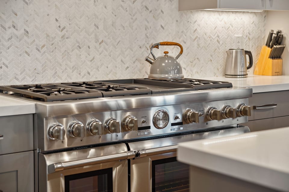 Professional-grade gas range set against a clean, textured backsplash—built for elevated home cooking experiences.