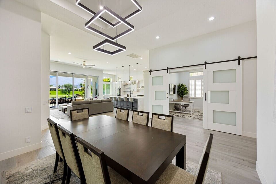 The dining area features a stunning pendant chandelier and seating for eight!