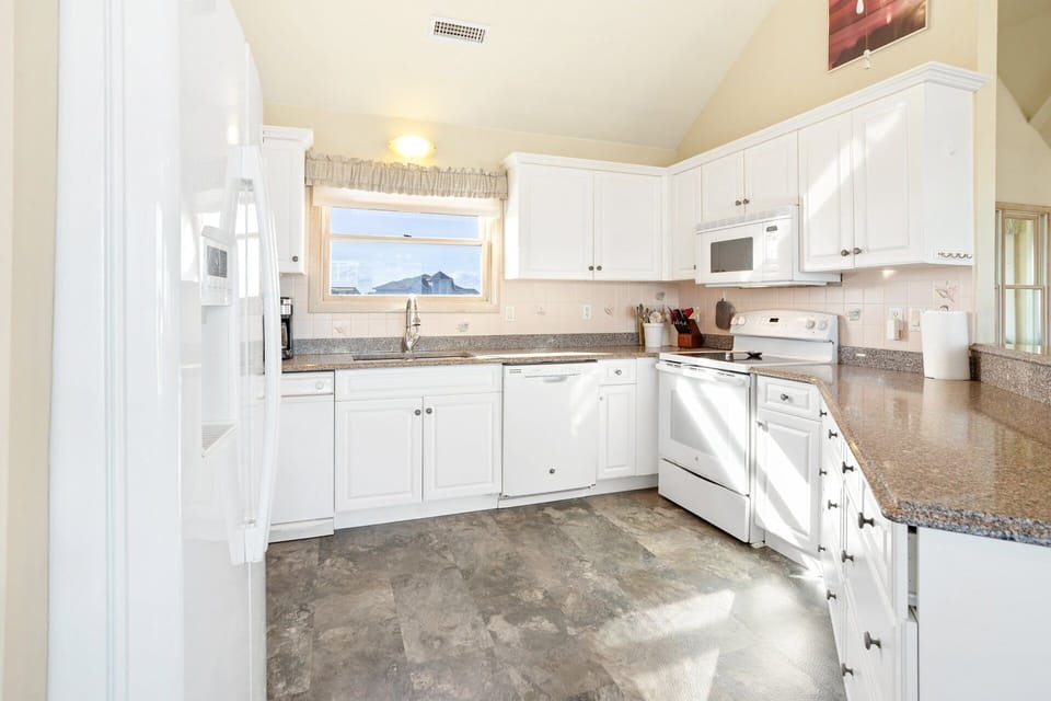 Kitchen: Fully equipped kitchen with modern appliances, breakfast bar seating, and plenty of prep space for family meals.