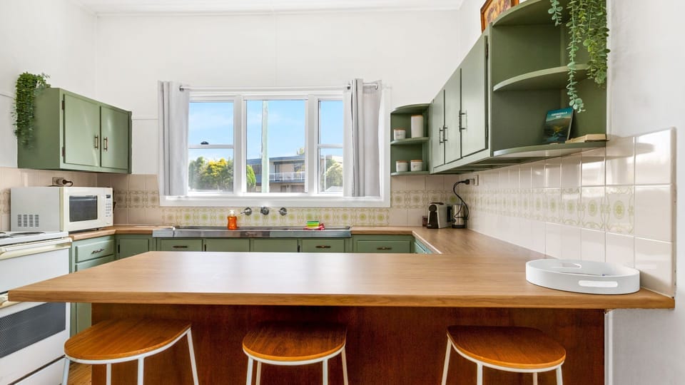 Fully equipped kitchen featuring retro-style cabinetry and modern conveniences.