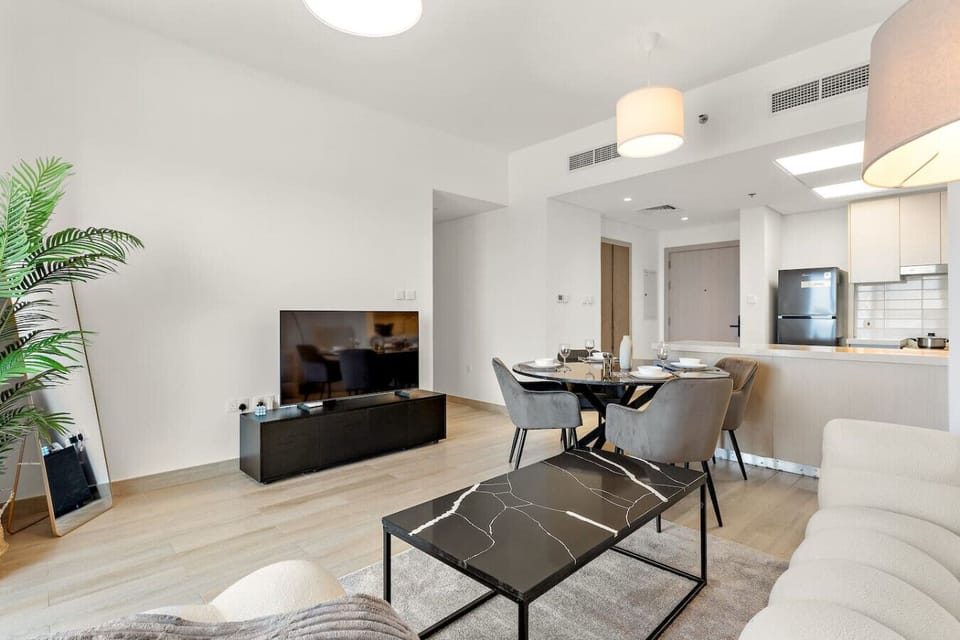Stylish living area with TV, dining space, and natural light-filled design.