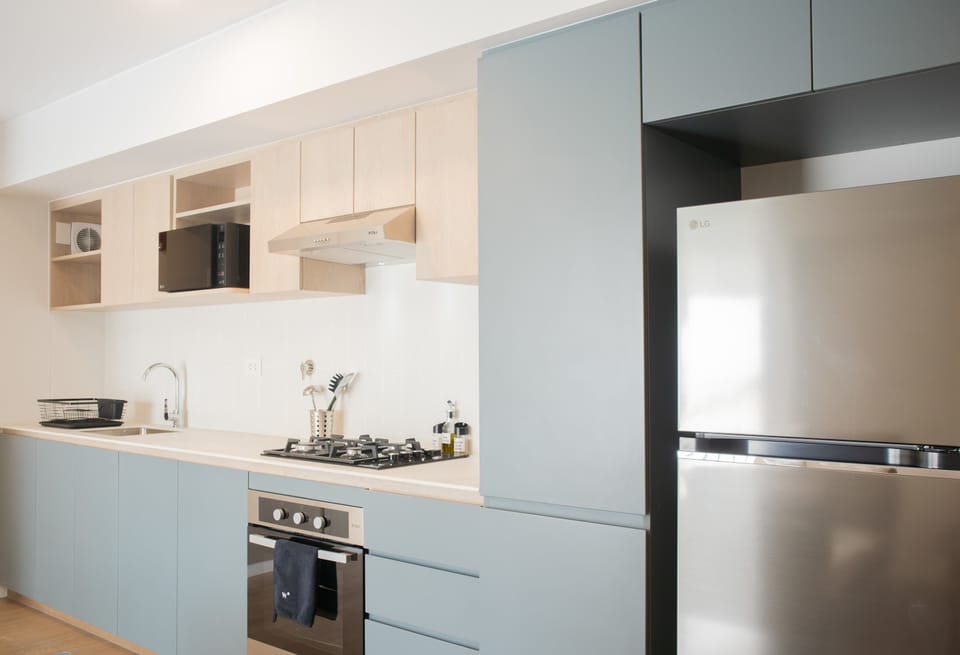 Modern kitchen with light blue cabinets and built-in appliances.
