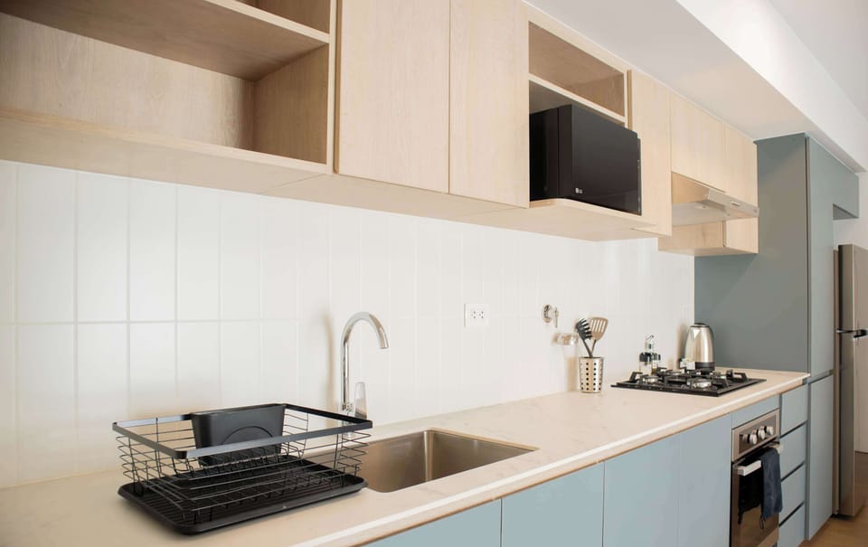 Functional kitchen with wooden details and under-shelf lighting.