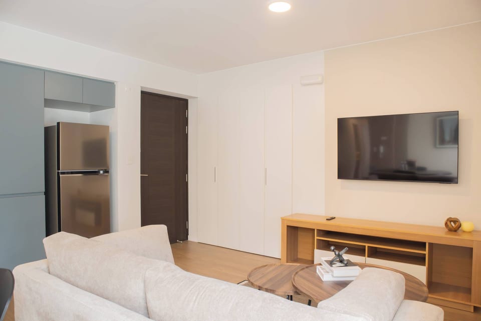 Living space with mounted TV and white sofa.