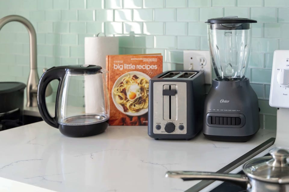 The kitchen is also equipped with small appliances such as electric kettle, toaster, and a blender.