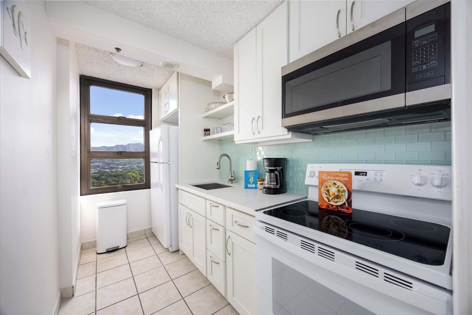 This kitchen is equipped with a stove and microwave for easy meal prep and added convenience.