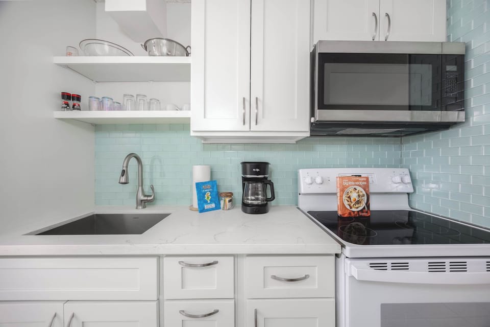 This kitchen is equipped with a stove and microwave for easy meal prep and added convenience.
