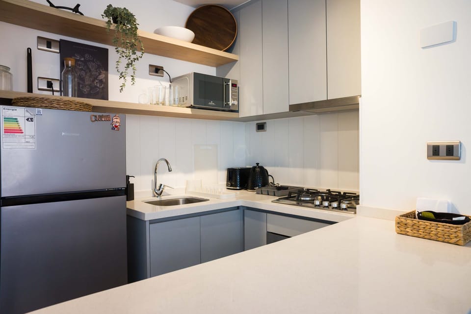 Modern kitchen with sleek appliances and stylish open shelving, perfect for culinary adventures.