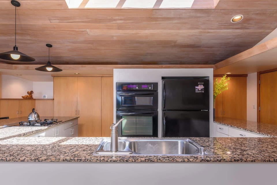 Fully equipped kitchen with granite countertops and bar seating.