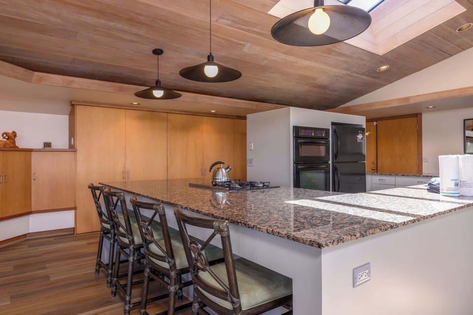 Fully equipped kitchen with granite countertops and bar seating.