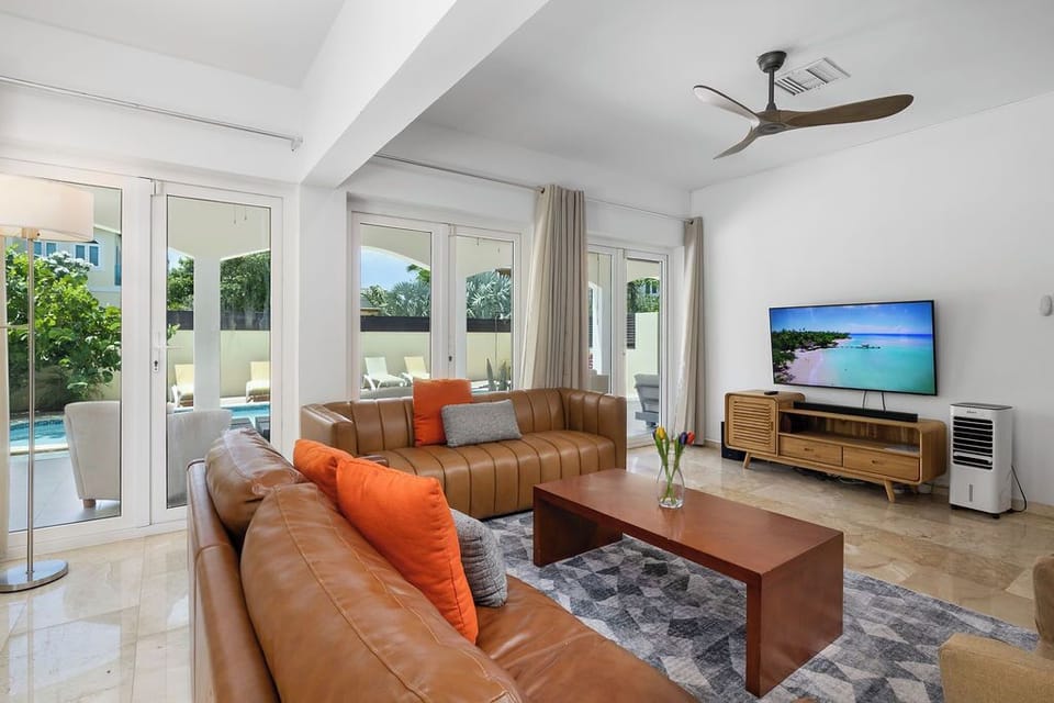Settle into your bright, airy living room with rich leather seating, tropical breezes from your ceiling fan, and glass doors opening to your private pool just steps away.