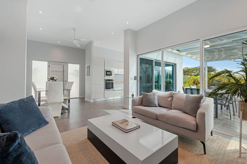 Bright and spacious living area with floor-to-ceiling glass doors.