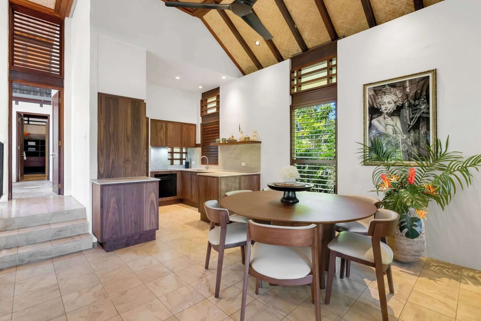 Gather around the round dining table for group meals and conversation, surrounded by calming tropical-inspired interiors that enhance the villa's laid-back atmosphere.