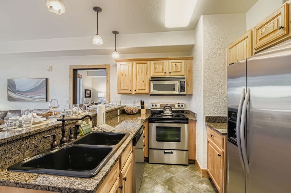 This chef-ready kitchen at Silverado Lodge features warm alder cabinetry, sleek granite countertops, and stainless steel appliances. The spacious breakfast bar is perfect for après-ski dining and entertainin