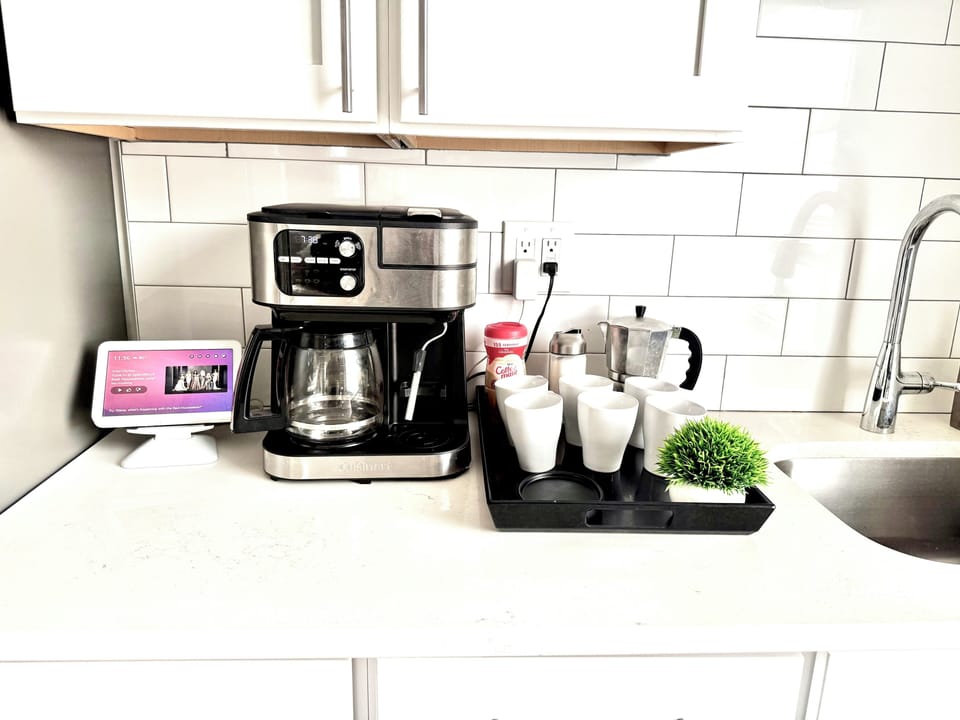 Modern coffee bar with multi-brew machine, mugs & smart display