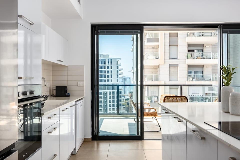 Modern kitchen layout connects seamlessly to balcony, making cooking and dining feel open and easy.