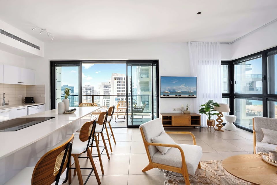 Wide layout connects kitchen and living areas, enhancing flow and making the apartment feel spacious.